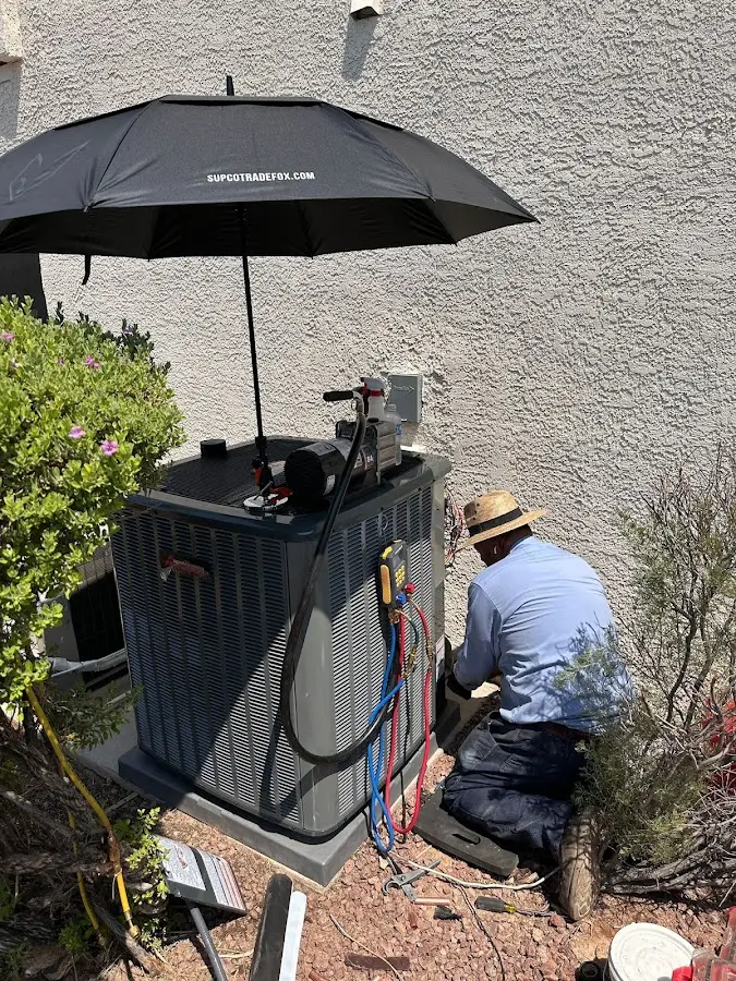 HVAC technician performing outdoor AC maintenance in St. George