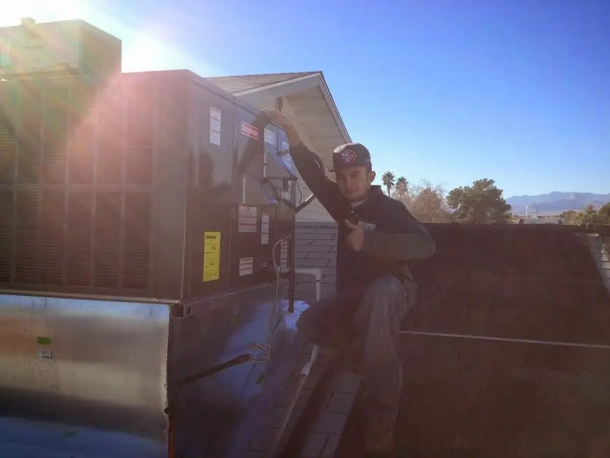 HVAC technician performing HVAC Inspection on a rooftop unit in St. George